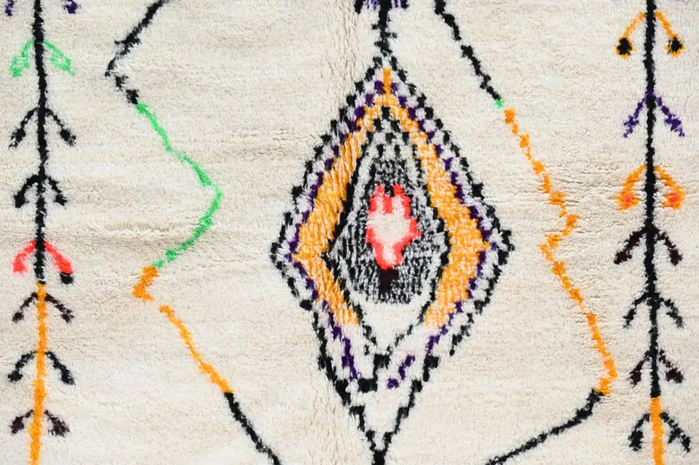 Cream-colored moroccan azilal rug with central diamond pattern in orange purple black and red accents 248x151 cm