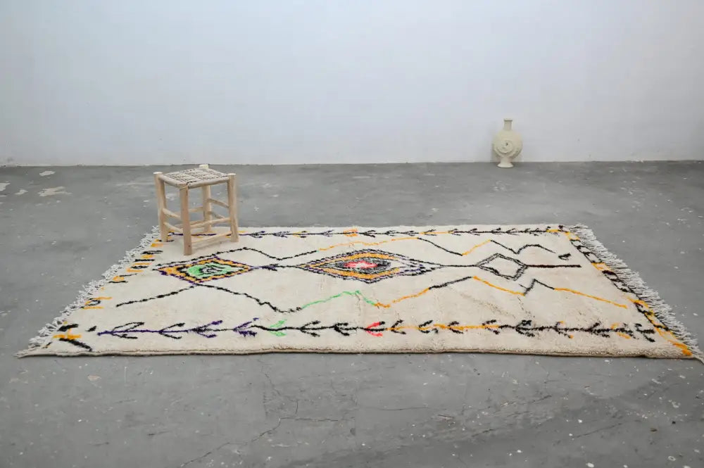 Cream-colored moroccan azilal rug with geometric black, yellow, green, and red accents by DecorBites 248x151 cm