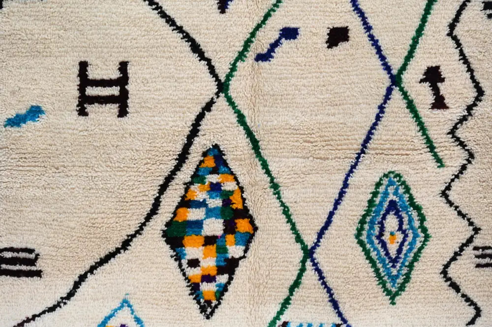 Cream-colored handmade moroccan azilal rug with intricate black green blue and orange geometric patterns 250x141 cm