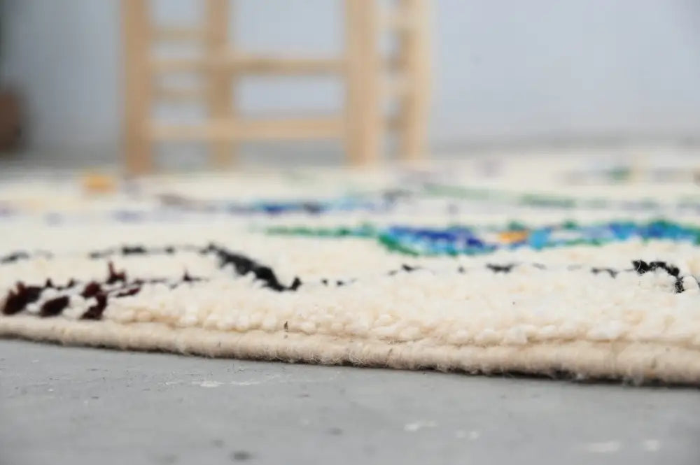 Cream-colored handmade moroccan azilal rug with intricate black blue and green geometric patterns 250x141 cm by DecorBites