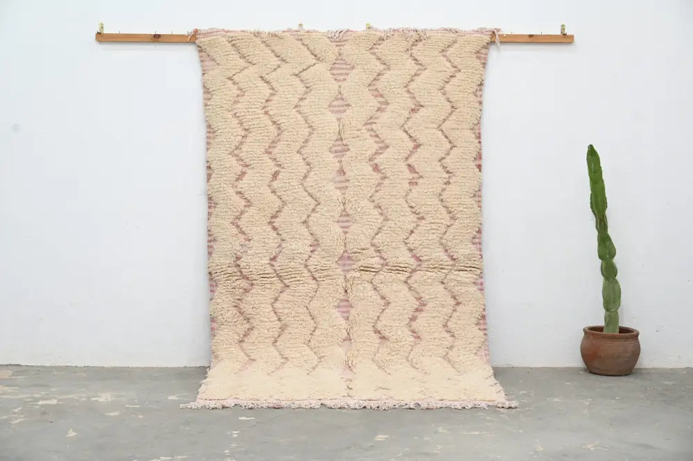 Beige and dusty rose handmade traditional azilal rug hanging on a wooden rod by decorbites 250x143cm