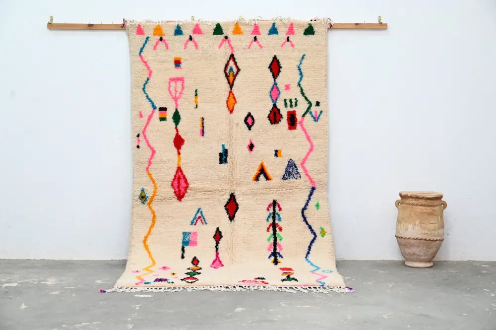 Beige moroccan azilal rug with vibrant pink orange blue green and red geometric patterns handmade by decorbites