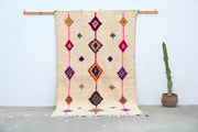 Beige handmade moroccan azilal rug with vibrant pink purple green and orange geometric patterns 250x148 cm decorbites