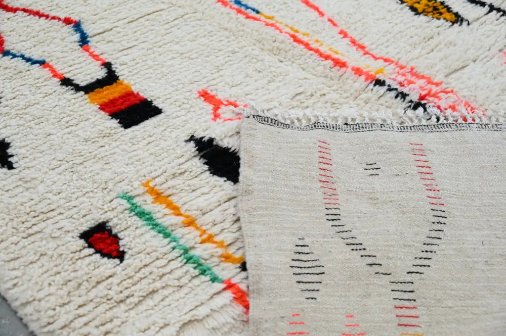 Cream-colored DecorBites™ handmade moroccan azilal rug with vibrant hand-knotted geometric patterns in multiple colors