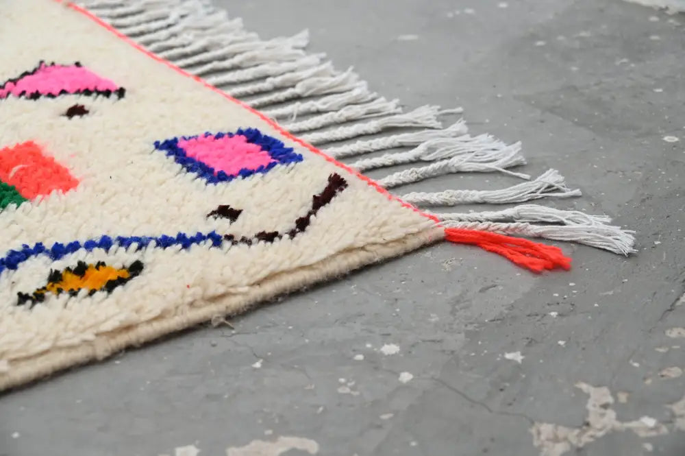 A vibrant cream-colored handmade DecorBites™ azilal rug 250x160cm with bold geometric patterns in natural wool