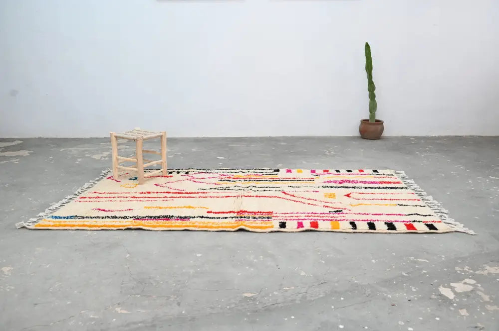 DecorBites™ handmade traditional azilal rug with cream base and vibrant pink black yellow red and orange geometric patterns
