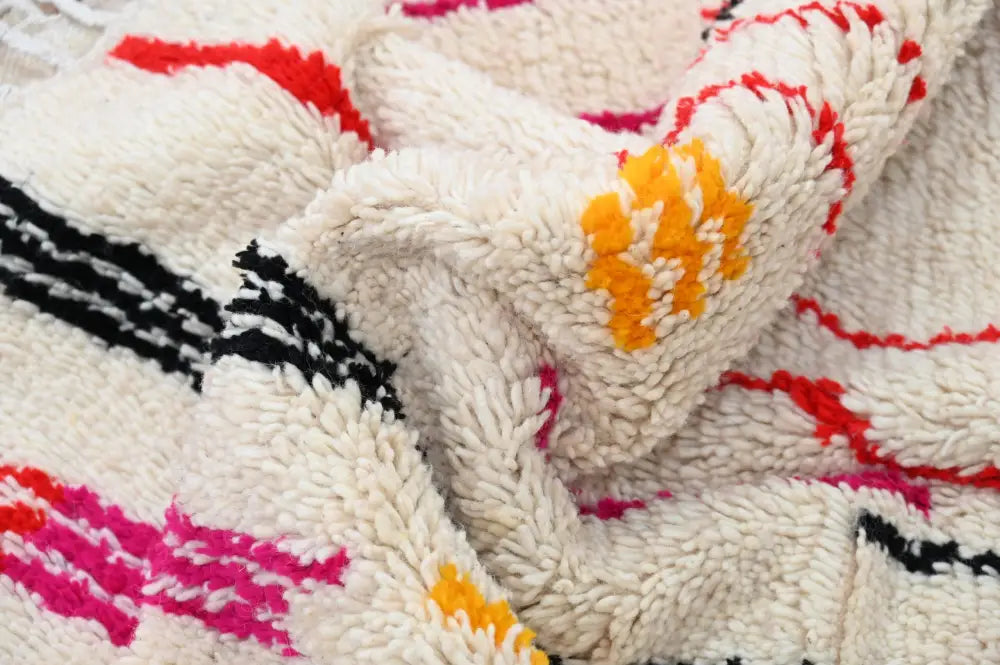 Cream-colored handmade traditional azilal rug with bold red black pink and orange geometric patterns 253x144 cm