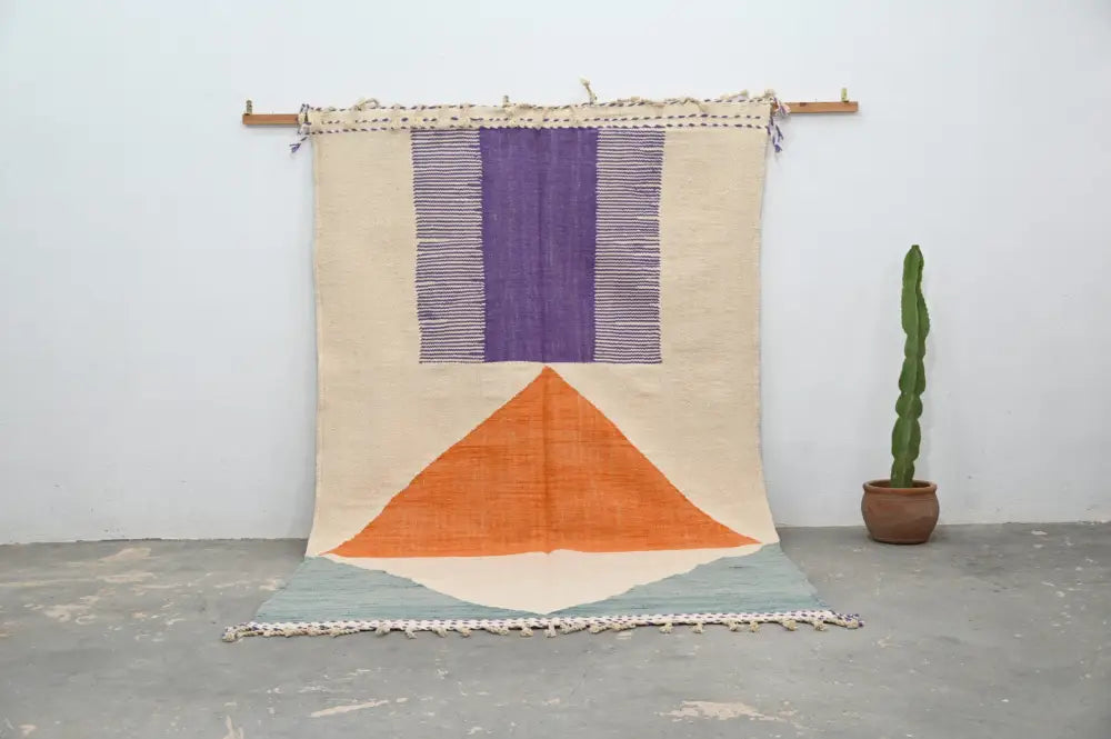 DecorBites™ handmade moroccan azilal rug with beige purple and orange geometric design in natural wool hanging on wooden rod