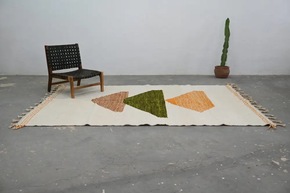Cream-colored handmade moroccan azilal rug with three geometric triangles in terracotta olive green and mustard yellow