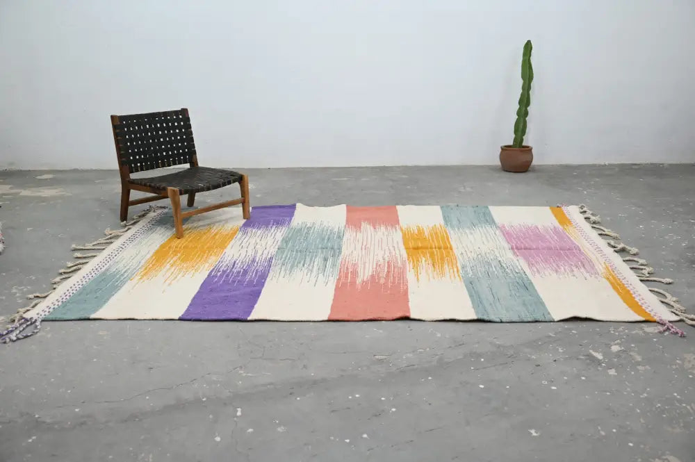 Colorful handmade moroccan azilal rug 302x197cm with bold pastel stripes and fringed edges by decorbites