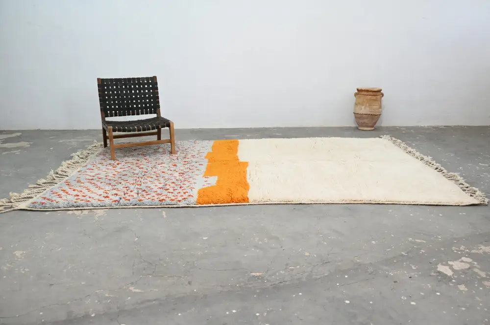 Cream-colored wool moroccan azilal rug with bold orange vertical stripe and fringed edges by decorbites 304 x 210 cm