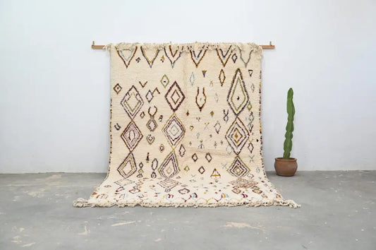 Cream-colored decorbites™ handmade moroccan azilal rug 305x206cm with intricate geometric patterns and fringed edges