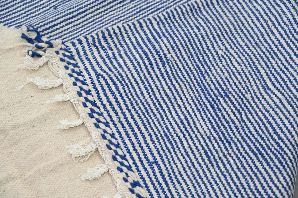 Blue and white striped woven textile with fringed edges in a decorbites handmade moroccan azilal rug 306x177cm