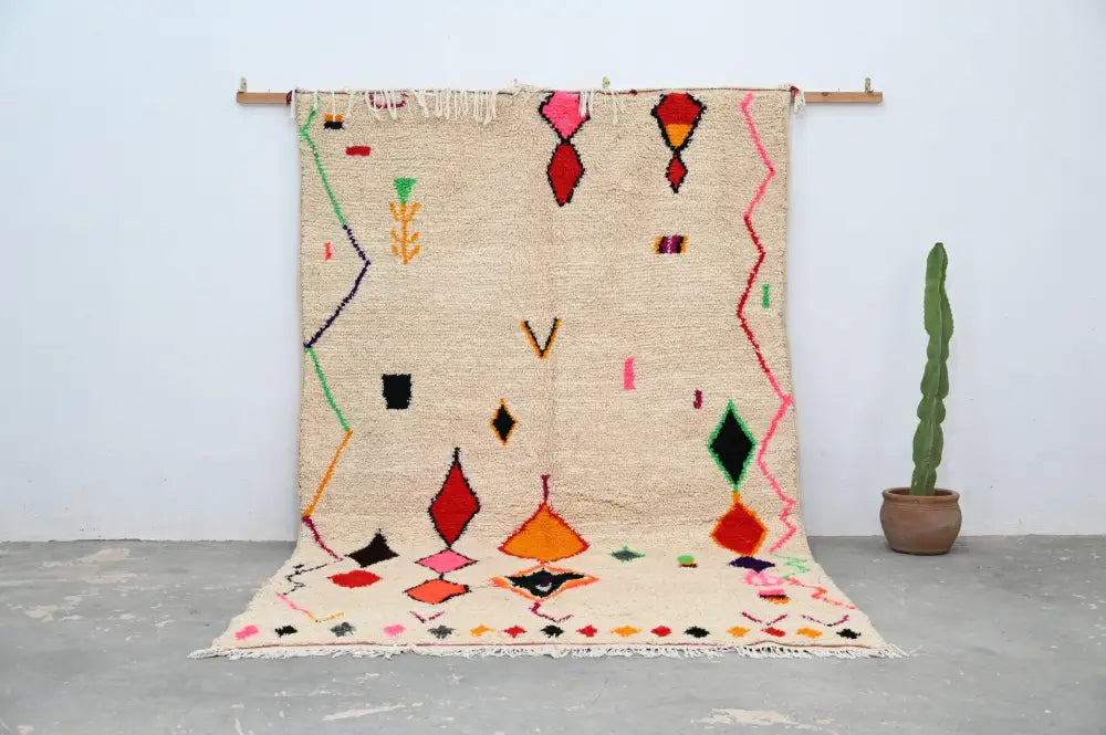 Beige handmade moroccan azilal rug with vibrant red orange green pink and black geometric patterns 309x195cm by DecorBites
