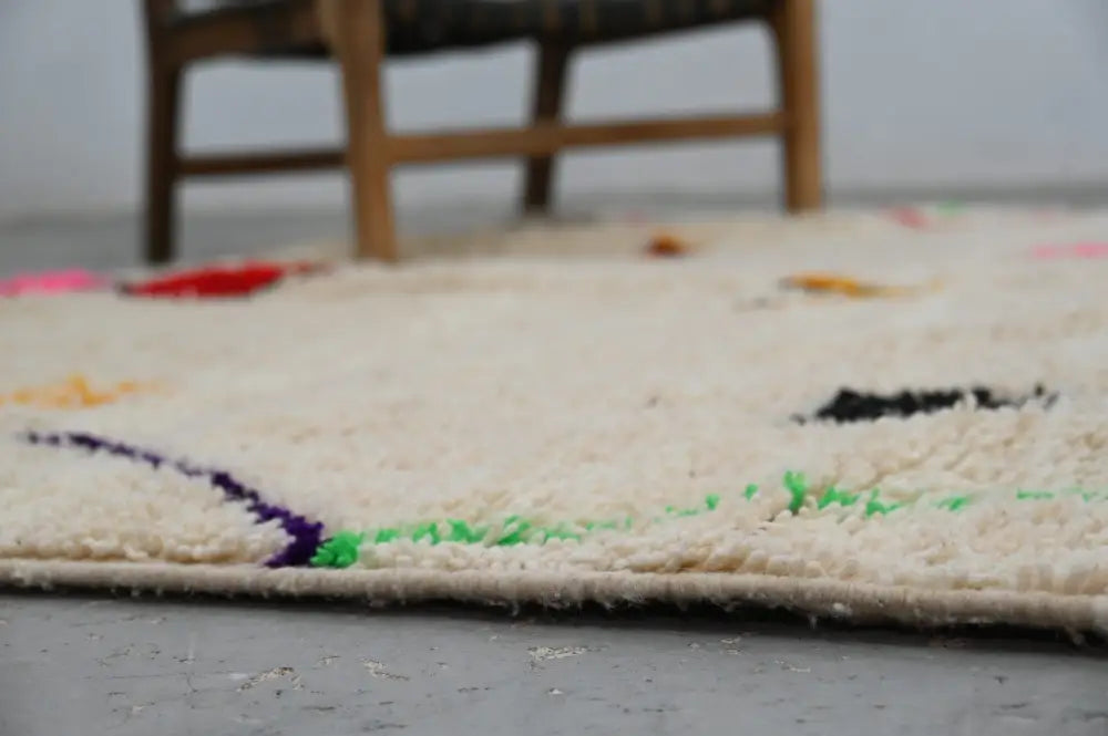 Cream-colored plush wool azilal rug with vibrant purple green and black embroidery handmade moroccan azilal rug 309x195cm