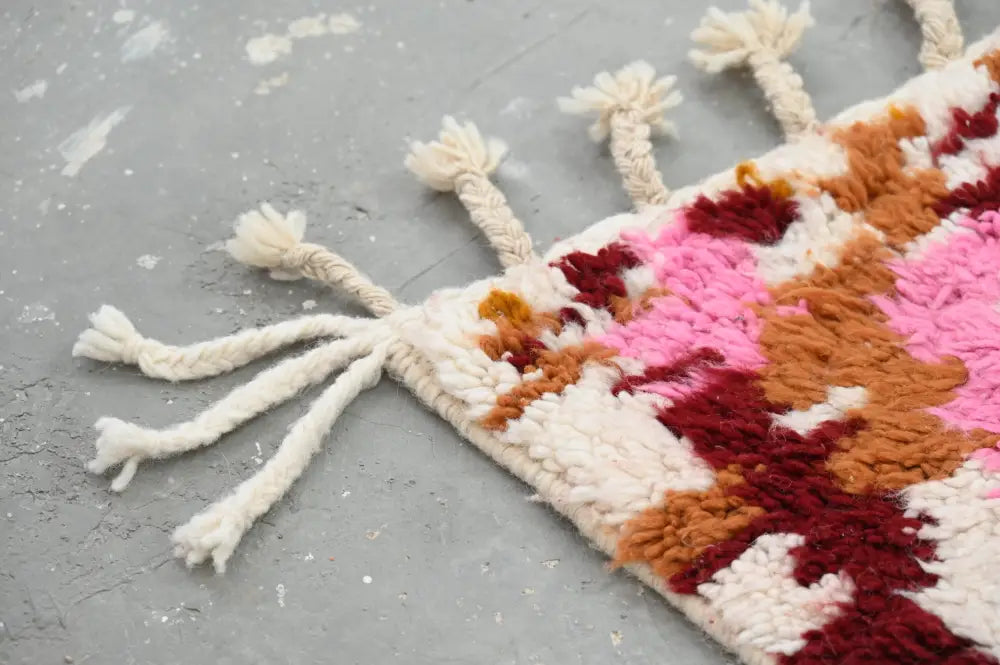 Decorbites™ handmade moroccan azilal rug with geometric pattern in pink rust and cream featuring fluffy tassels