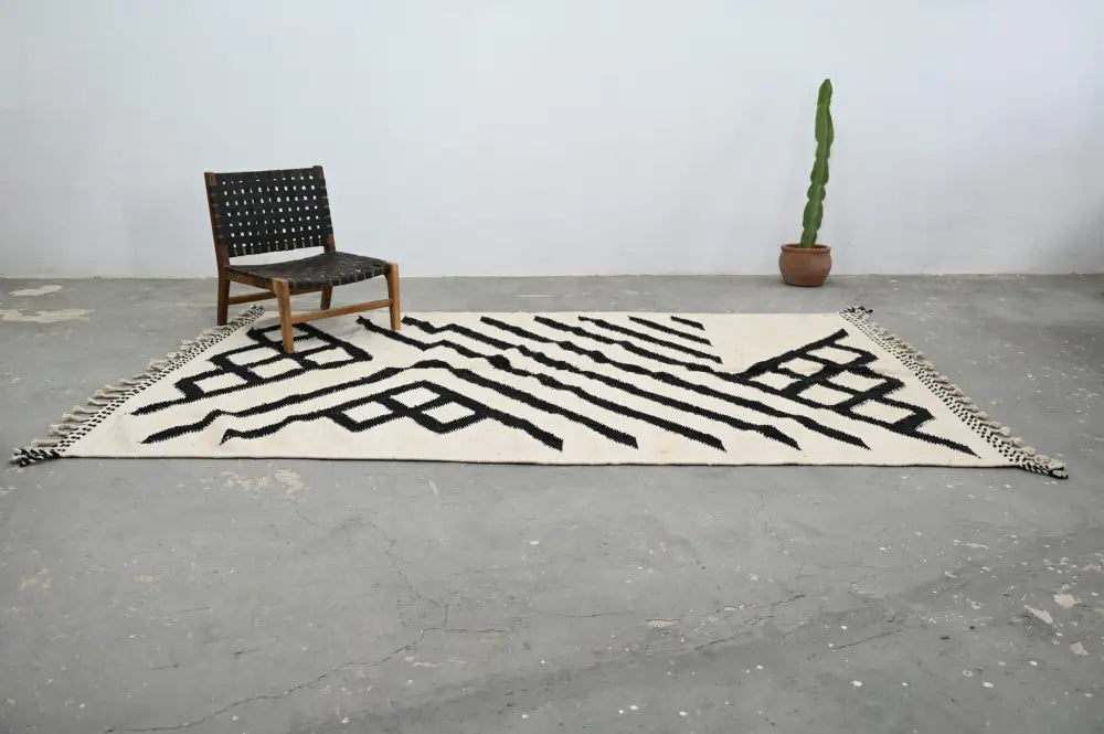 Cream-colored handmade Moroccan azilal rug with bold black geometric patterns and fringed edges 317x200 cm