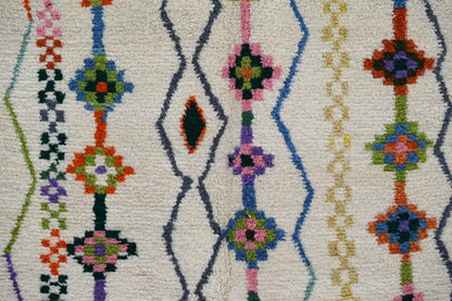DecorBites™ handmade traditional azilal rug with cream base and vibrant geometric patterns in blue green pink and orange
