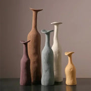 A set of five handcrafted ceramic flower vases in earthy tones with unique sculpted shapes for luxury home decor
