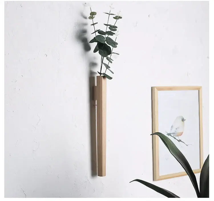 DecorBites™ handmade nordic wall vase in solid wood holding fresh eucalyptus mounted on a minimalist wall