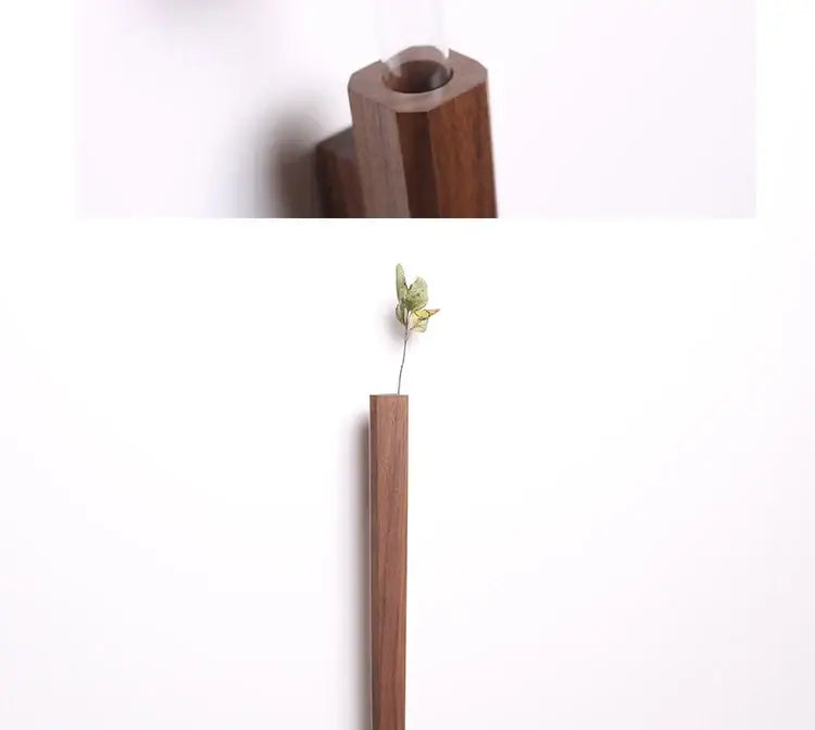 DecorBites handmade nordic wall vase in dark brown solid wood with a minimalist design holding a dried green flower