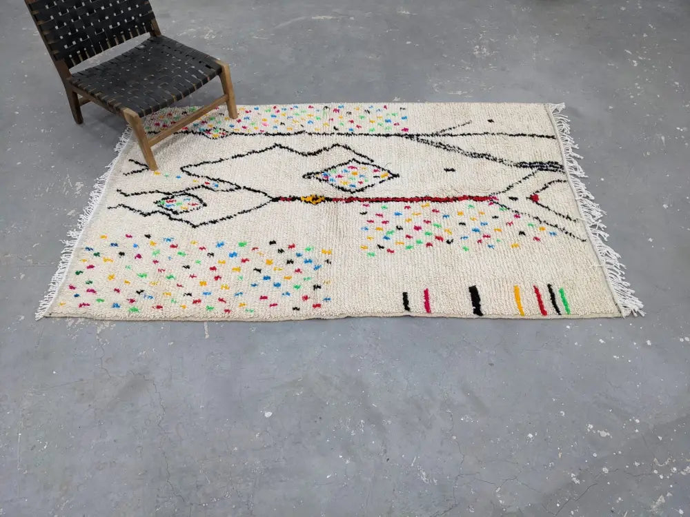 Beige handwoven moroccan azilal rug with black red and multicolored geometric patterns and fringe 234x147 cm