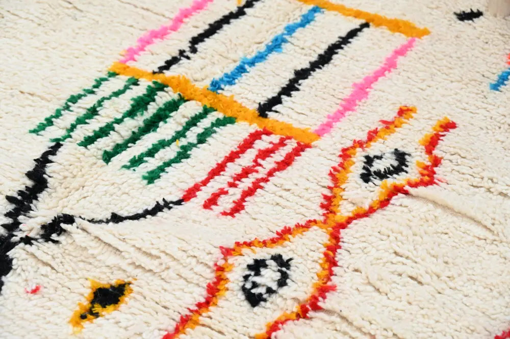 Cream-colored handwoven moroccan azilal rug with bold geometric patterns in pink blue green red and black yarns 245x146 cm