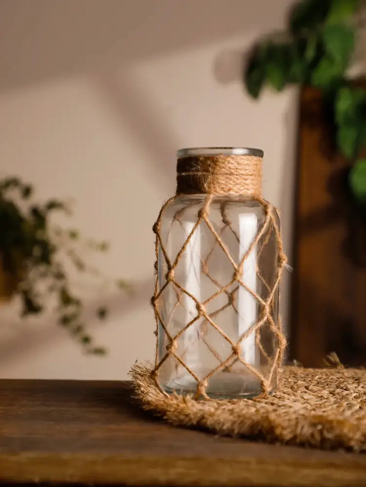 DecorBites™ hanging glass vase with silver lid wrapped in natural hemp rope forming a rustic diamond pattern