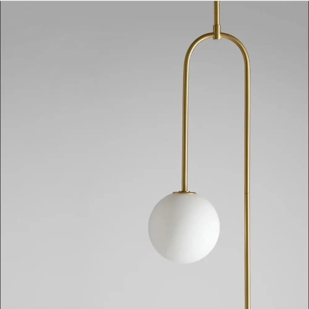 A decorbites™ hanging light with a gold finish metal frame and white glass shade offering versatile lighting options