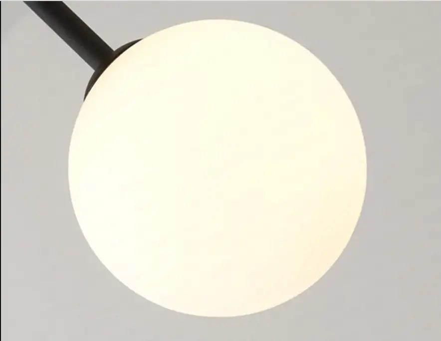 A sleek black spherical pendant hanging light with frosted glass globe offering versatile lighting options