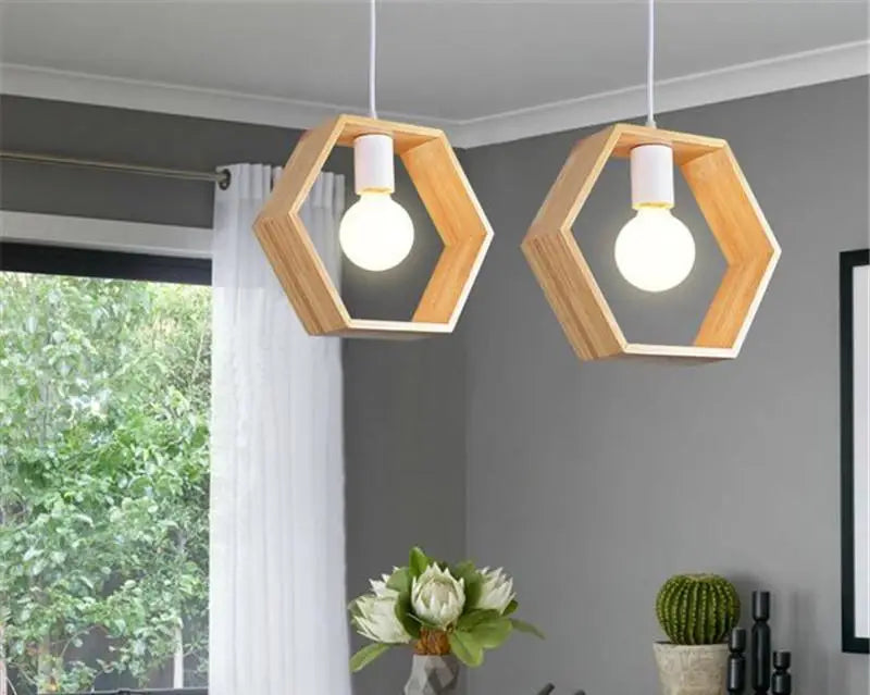 Two decorbites™ hanging wooden lights with hexagonal wooden frames and white cylindrical fixtures with exposed bulbs