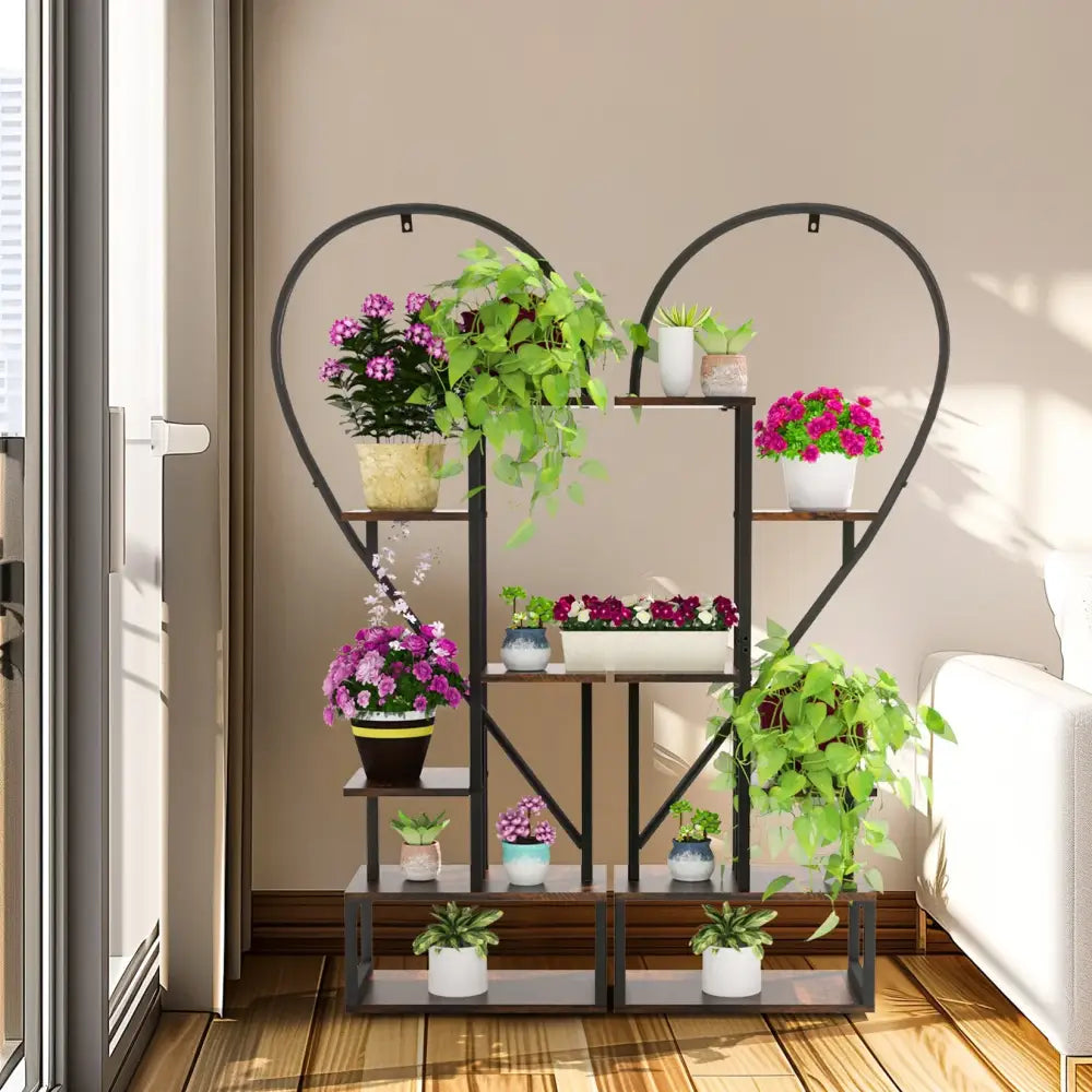 Black metal heart shaped plant stand with six tiers holding colorful potted plants by DecorBites™