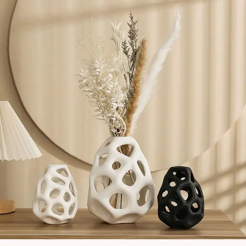 White ceramic vase with geometric perforated design holding dried botanicals in nordic classical style decorbites