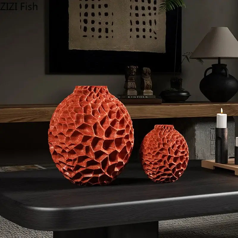 Two orange terracotta ceramic decorbites honeycomb vases with textured desk decor on a dark wooden table