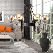 Black metal chandelier with four amber clear glass globe shades and gold accents for modern living room lighting