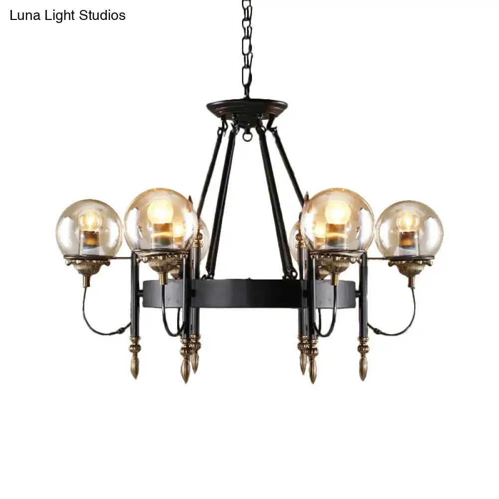 Black wrought iron chandelier with four amber clear glass globes and brass accents for modern living room lighting