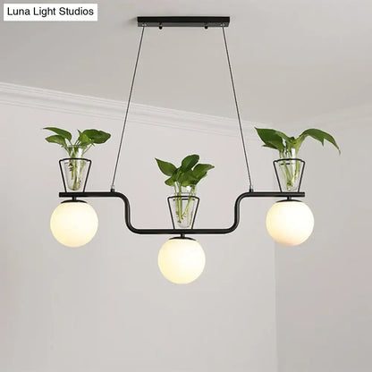 Decorbites industrial black island light fixture with three opal glass globe pendants and clear glass pots with plants