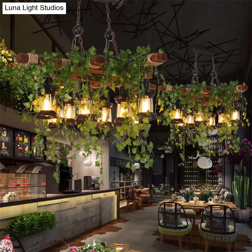 A rustic decorbites industrial black metal lantern island light with wooden beams and green ivy vines hanging lanterns