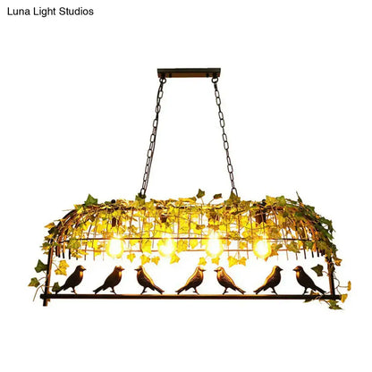 Wrought iron bird-themed pendant light with golden finish and green imitation leaf accents for dining room decor