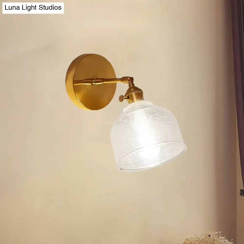 Gold-toned industrial brass wall sconce with textured clear glass dome wall shade for bedroom lighting