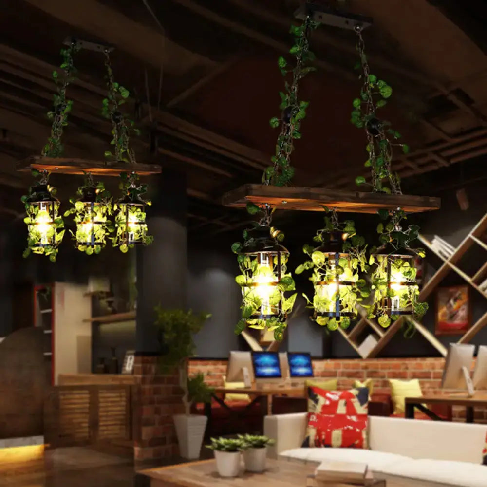 Rustic wooden beam pendant lights with clear glass cylindrical heads and hanging green vines for restaurant island light decor