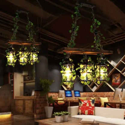Rustic wooden beam pendant lights with clear glass cylindrical heads and hanging green vines for restaurant island light decor