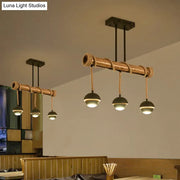 Rustic industrial linear island chandelier with bamboo tube and rope, black iron frame, and dark matte dome bulbs