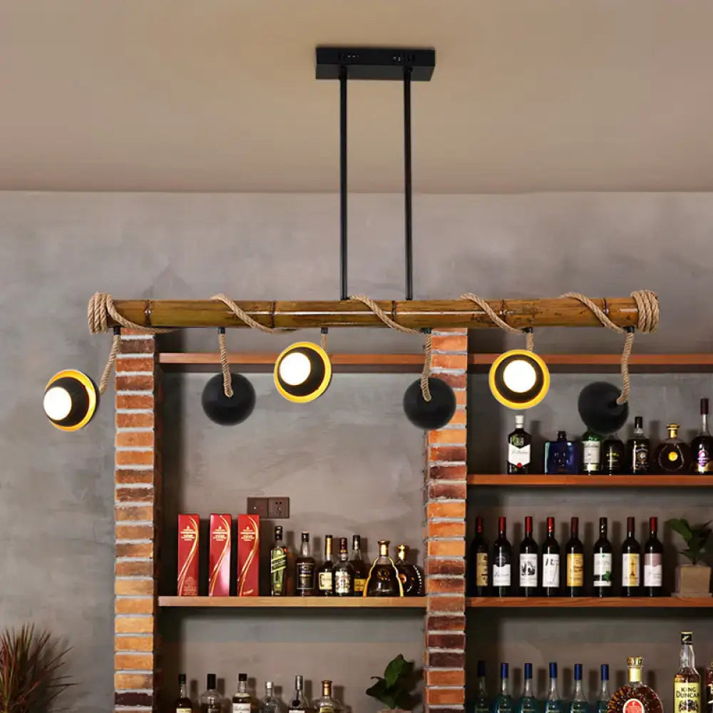 Industrial linear chandelier with bamboo tubes black iron rods rope accents and yellow gold illuminated fixtures