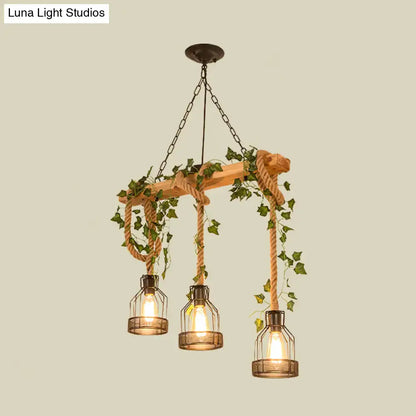 Decorbites industrial metal caged island pendant light with three brown glass lanterns hanging by rope and green ivy