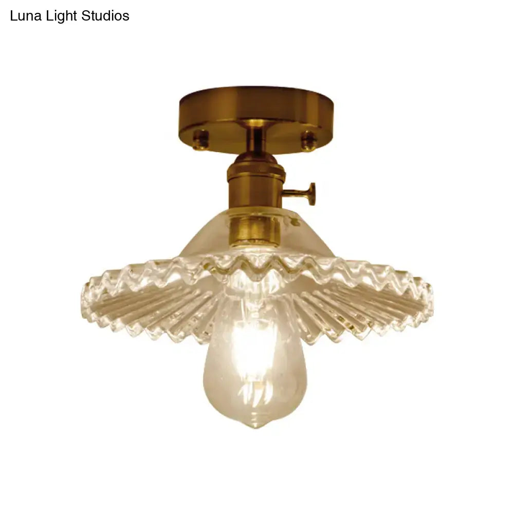 Brass-finished one-light ceiling light with clear scalloped ribbed glass shade and exposed bulb by DecorBites Industrial
