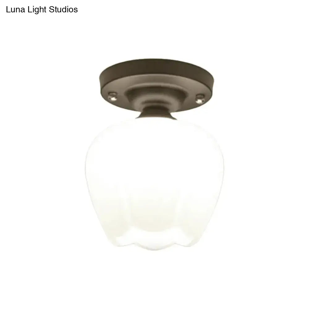 A frosted black opal glass globe with dark bronze metal base in an industrial semi flush corridor ceiling light by decorbites