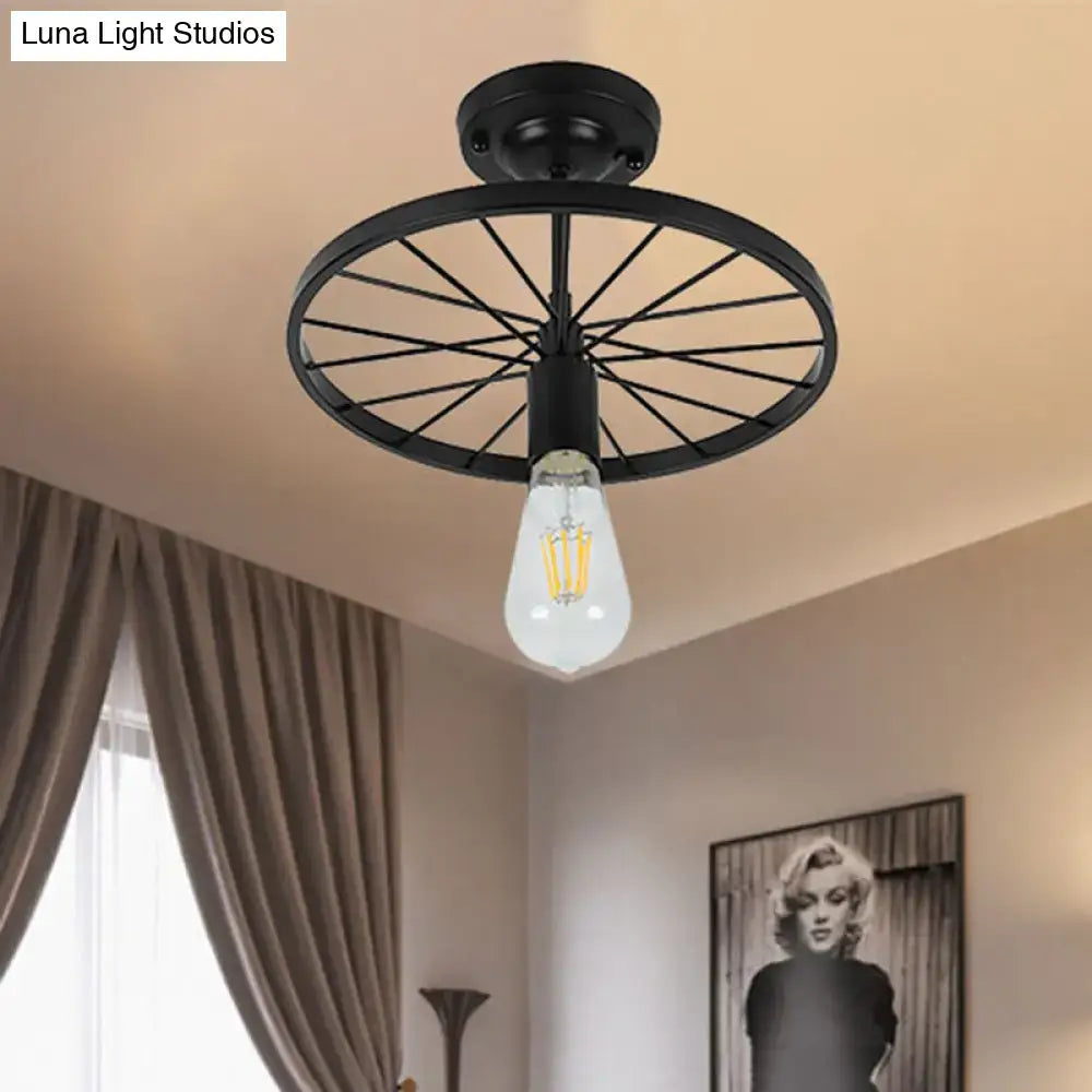 Black metal semi-flush mount ceiling light with bicycle wheel design and exposed filament bulb in industrial style