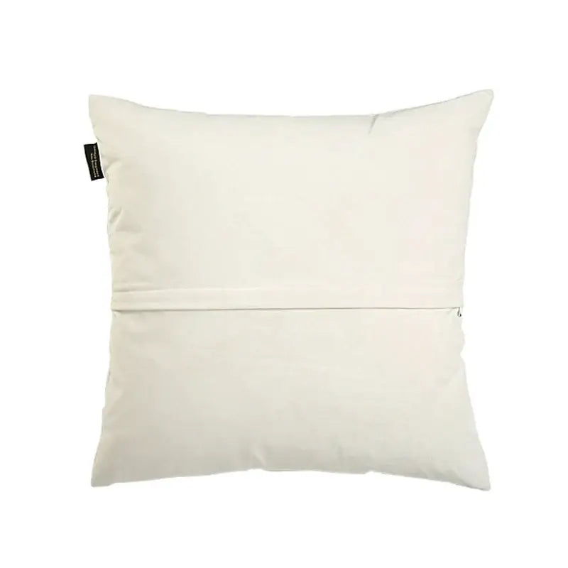 Cream-colored cushion cover with subtle seam and black tag back side of decorbites intersecting geometric velvet design