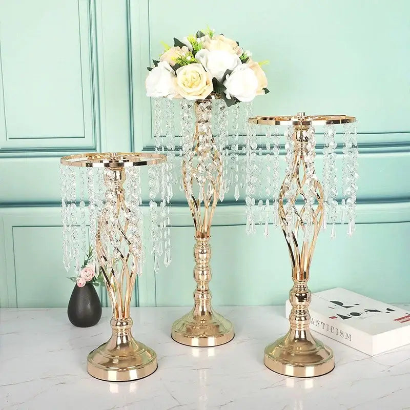 Three elegant gold-toned crystal chandeliers with clear glass beads on iron flower racks for dining table decoration